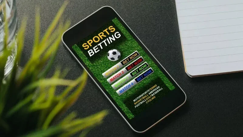 Engaged Bangladeshi sports enthusiast tracking live cricket statistics across multiple screens.
